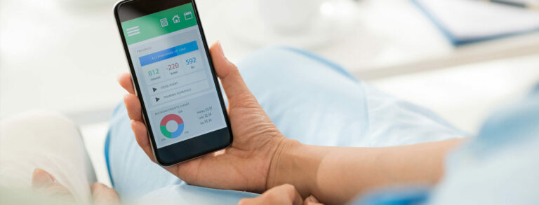 Eine Person hält ein Smartphone in der Hand, das eine Benutzeroberfläche mit Diagrammen und Statistiken zeigt.
